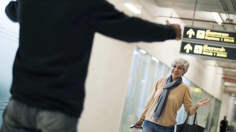 Two people greeting each other at the airport