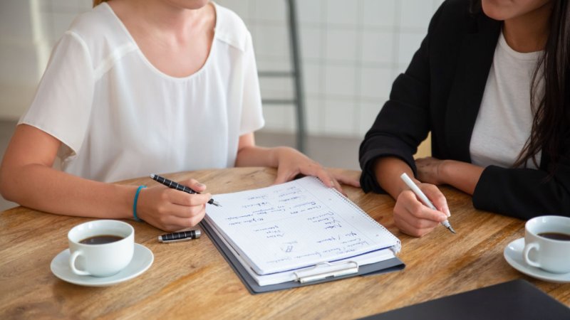 Two women sitting at a desk.